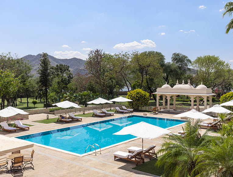 Swimming pool surrounded by greenery at Trident Udaipur, a 5 star hotel in Udaipur for a peaceful retreat.
